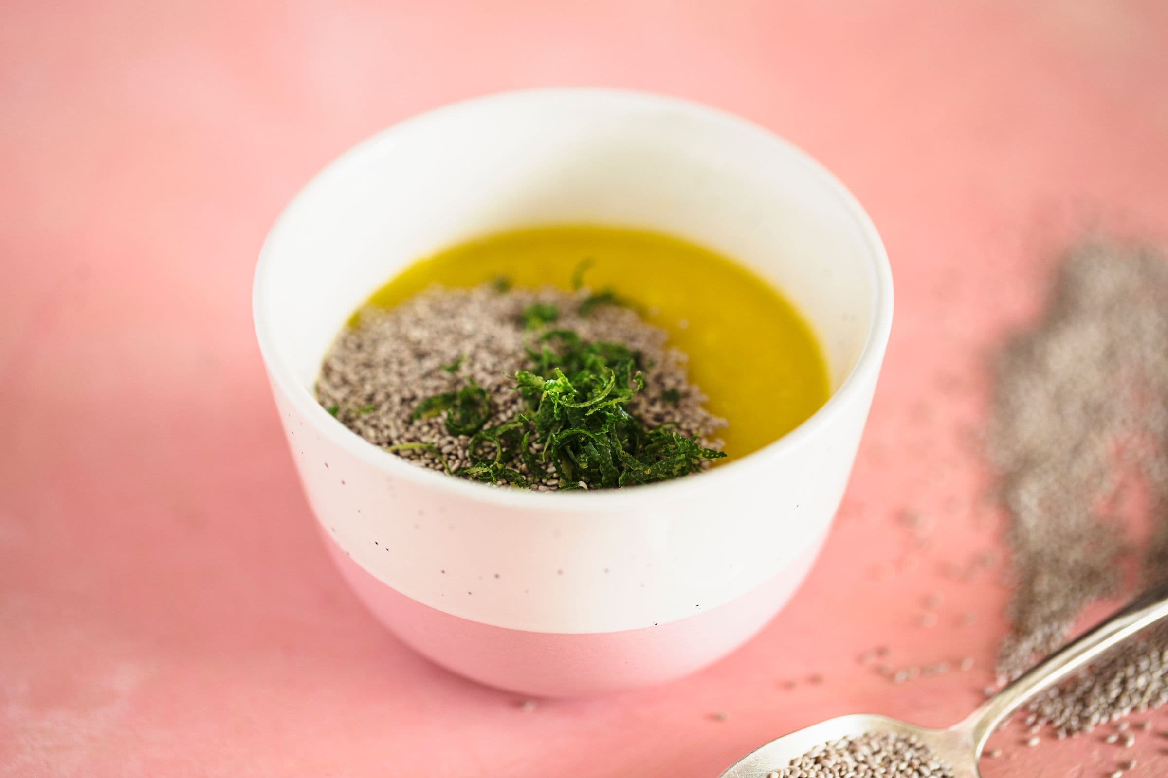 Bowl of mango chia jam base with lime zest and seeds on top, ready to mix.