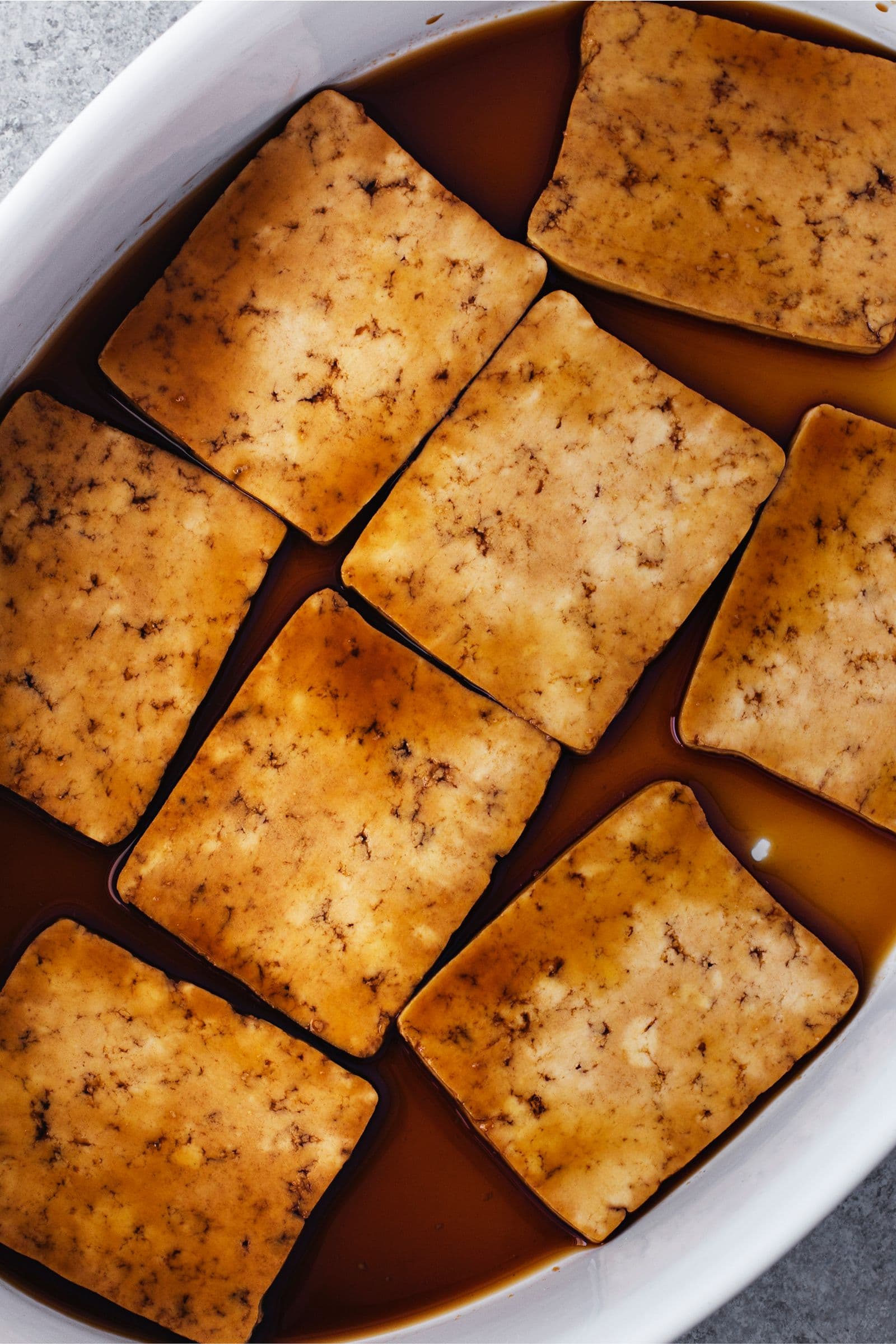 Tofu slices marinating in maple and soy mix.