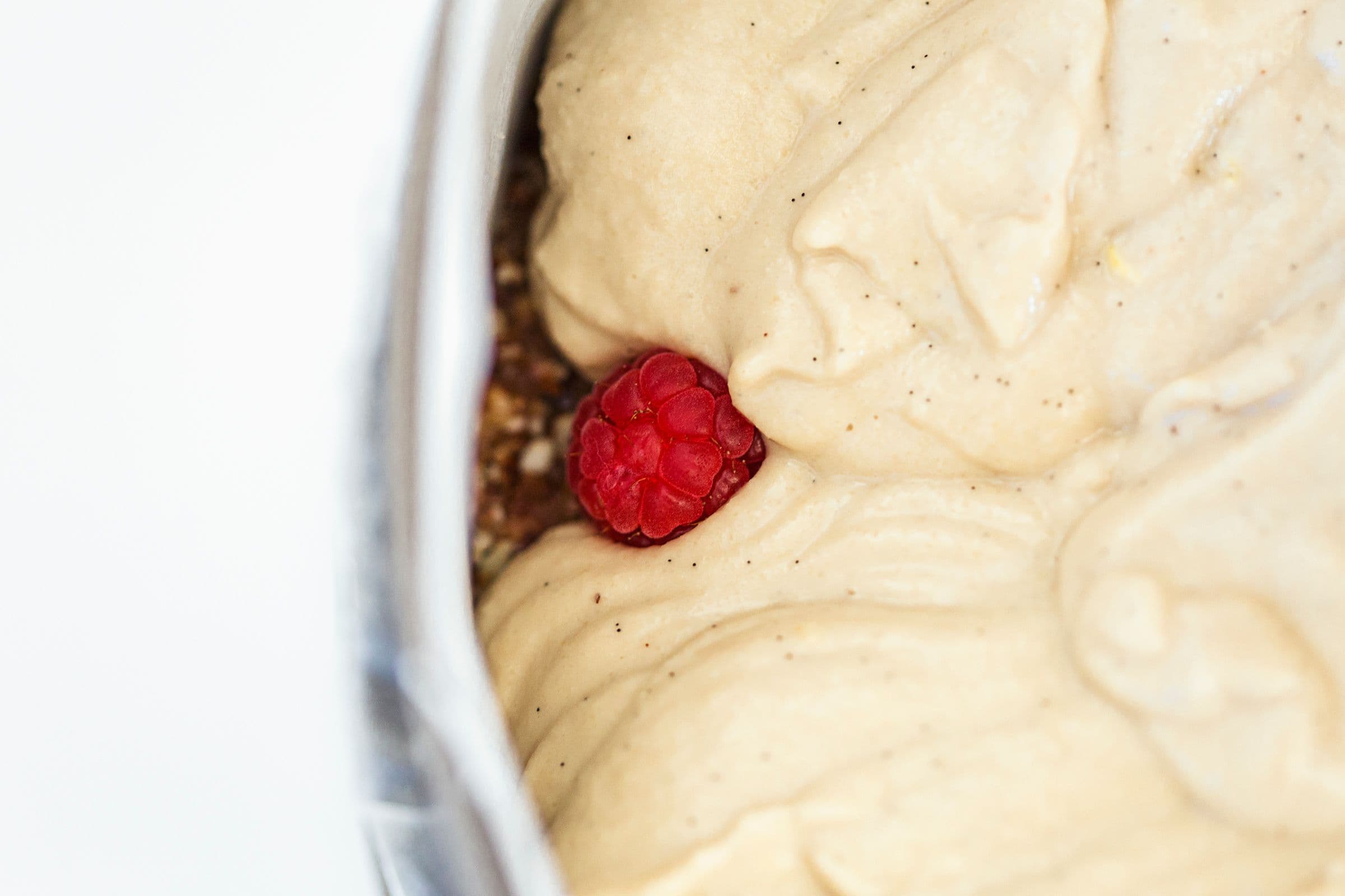 Close-up of the creamy filling with a single raspberry peeking through.