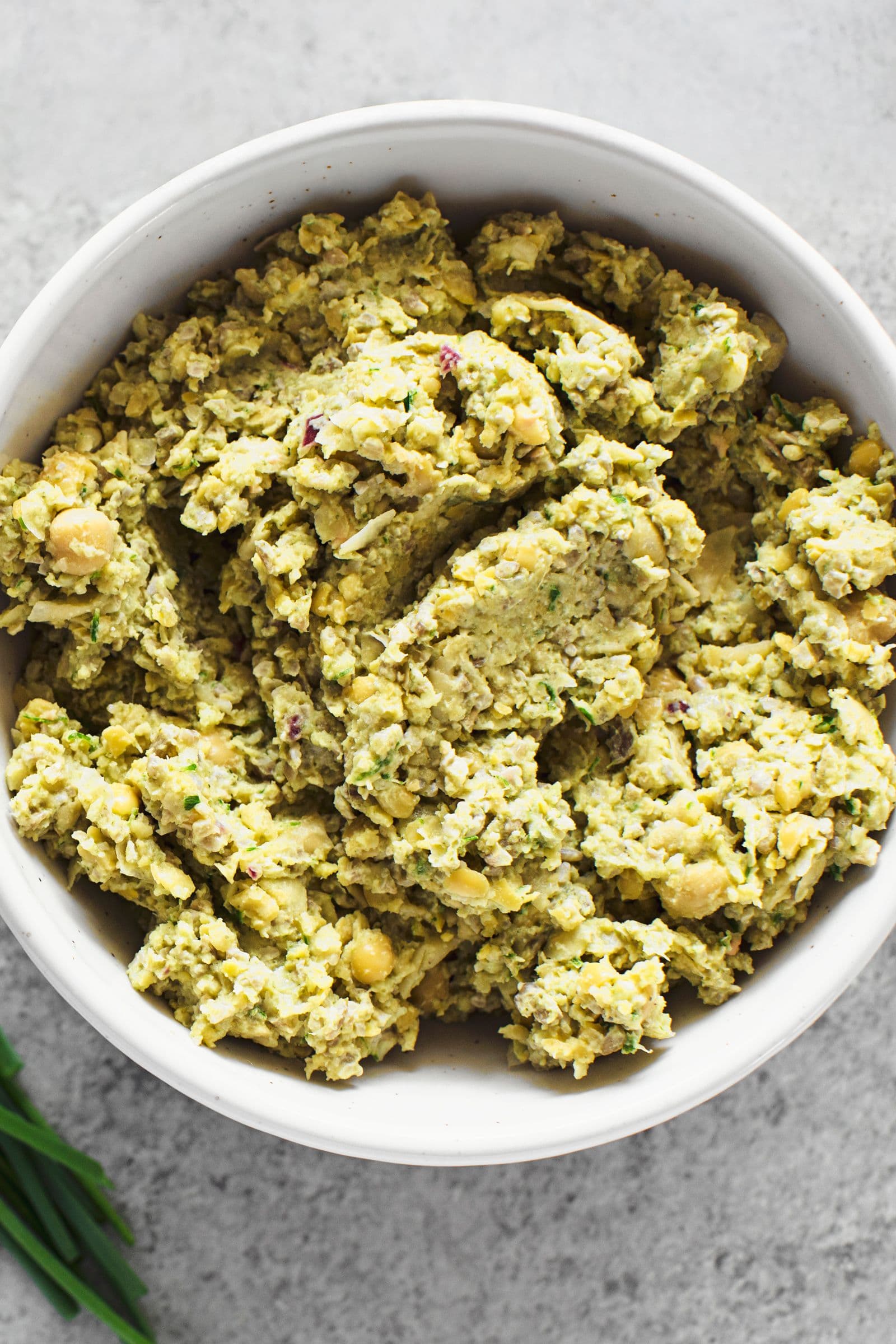 Thick chickpea and sunflower seed spread served in a white bowl.
