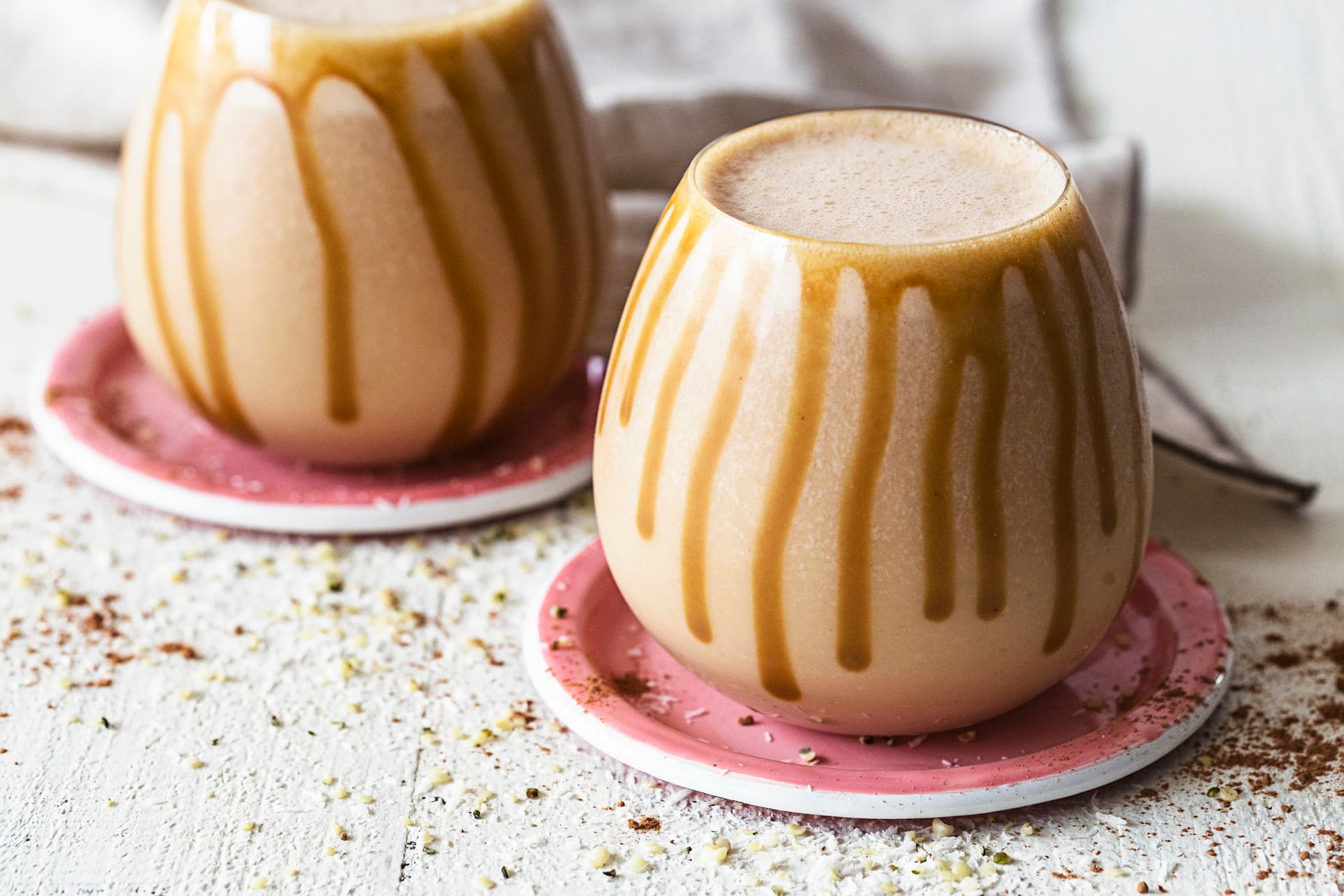 Close-up of a creamy smoothie with salted caramel drizzles running down the glass.
