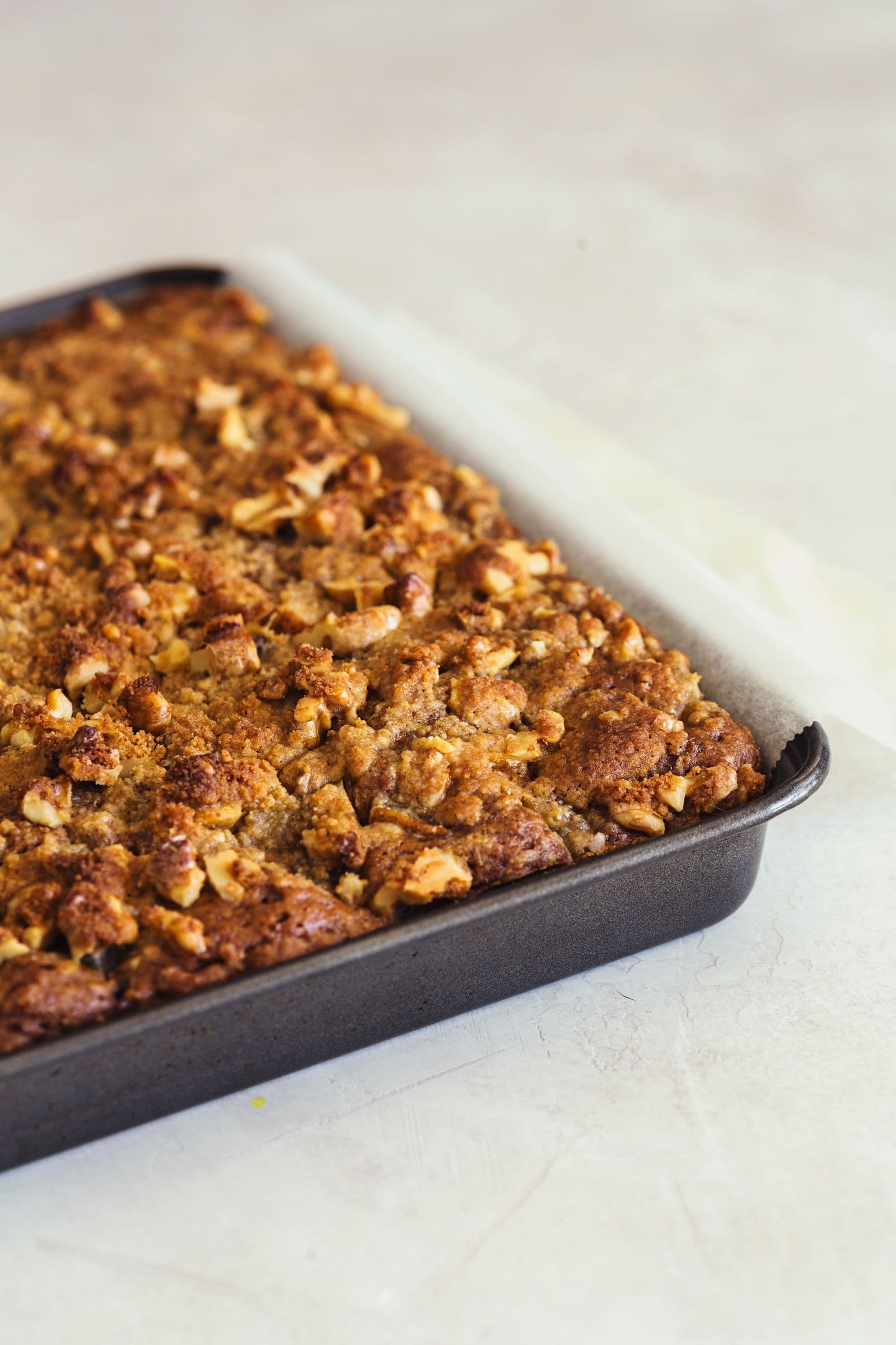 The baked coffee and pear cake resting in its rectangular tin, ready to slice.