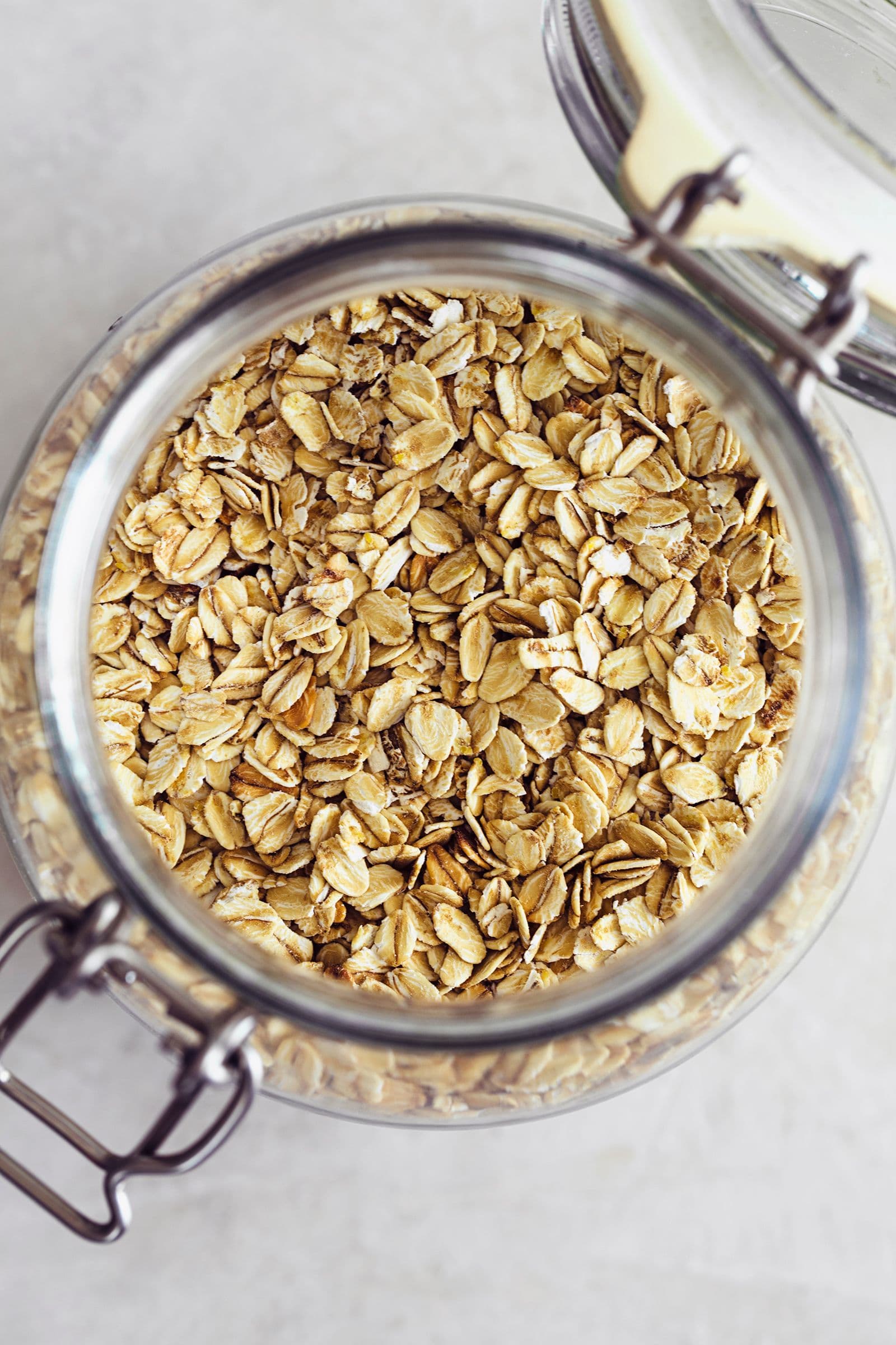 Top view of an open glass jar filled with rolled oats.