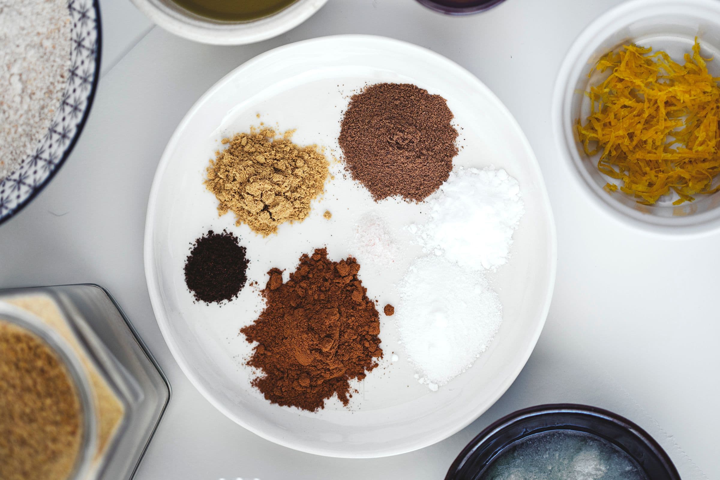 A small ceramic dish filled with spices ready to be combined.