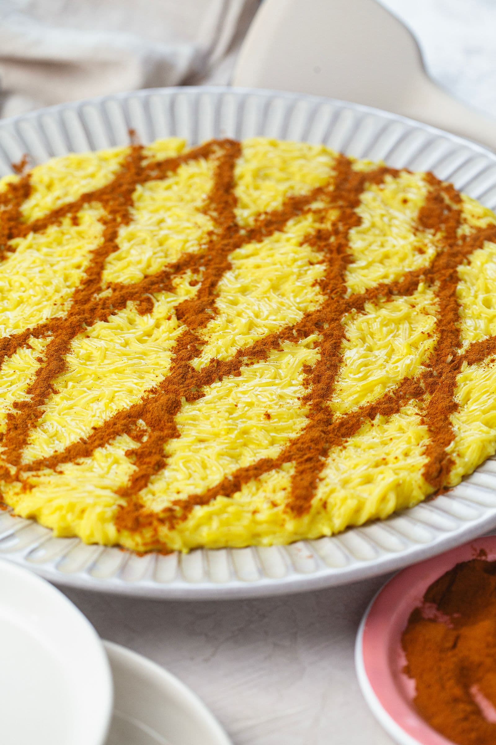 Side view of vegan Aletria on a serving plate, topped with a cinnamon lattice pattern.