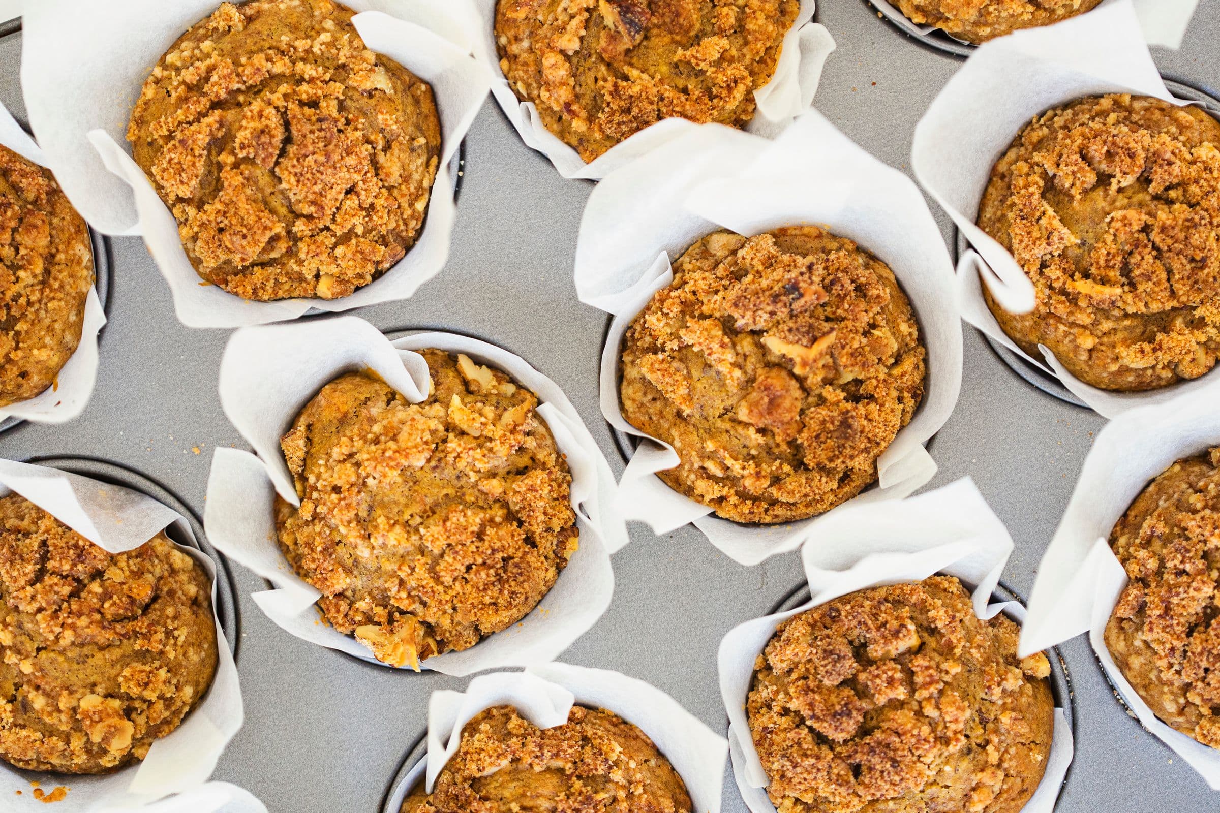Tray of freshly baked muffins with visible crumb topping.