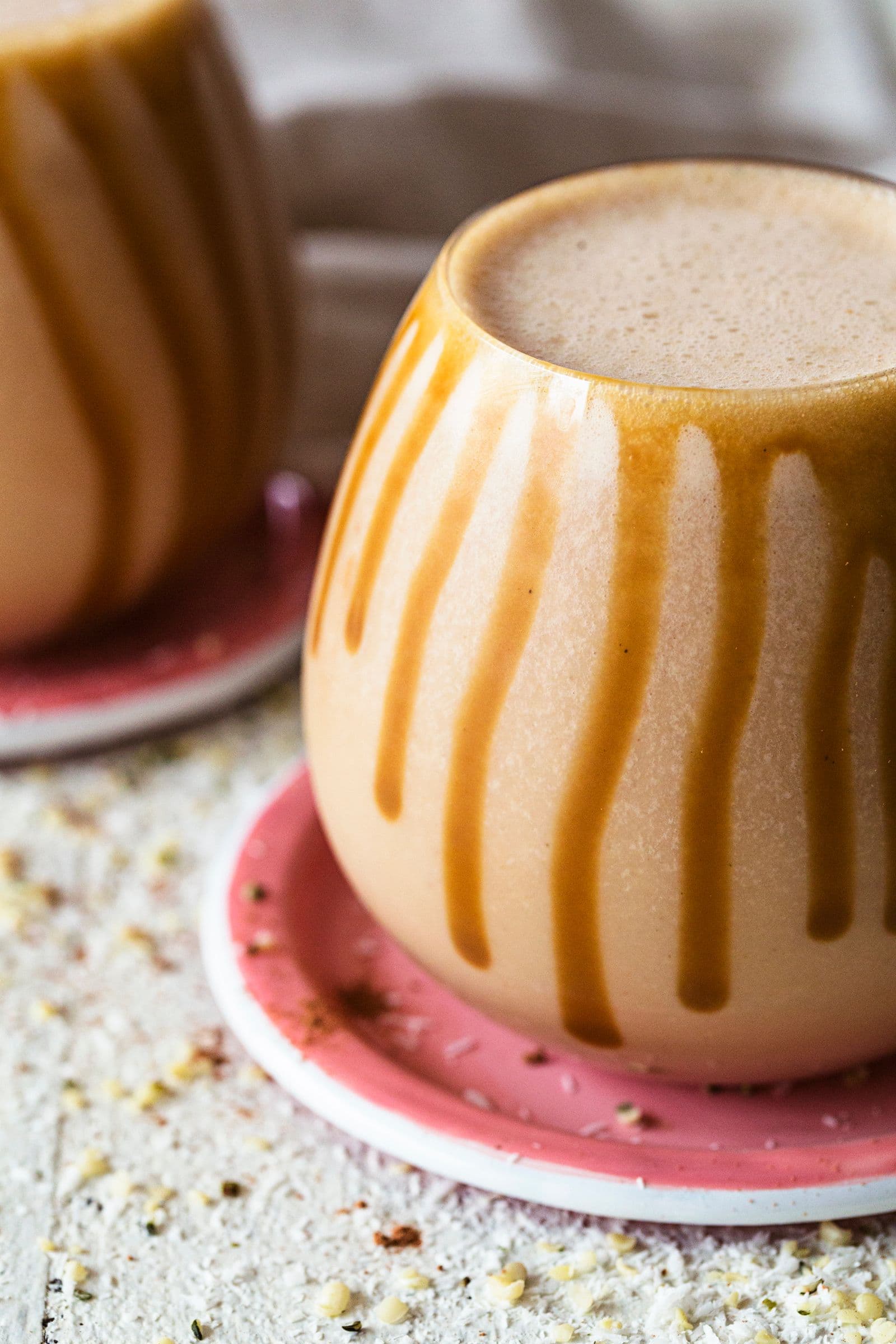 Close-up of a creamy smoothie with salted caramel drizzles running down the glass.
