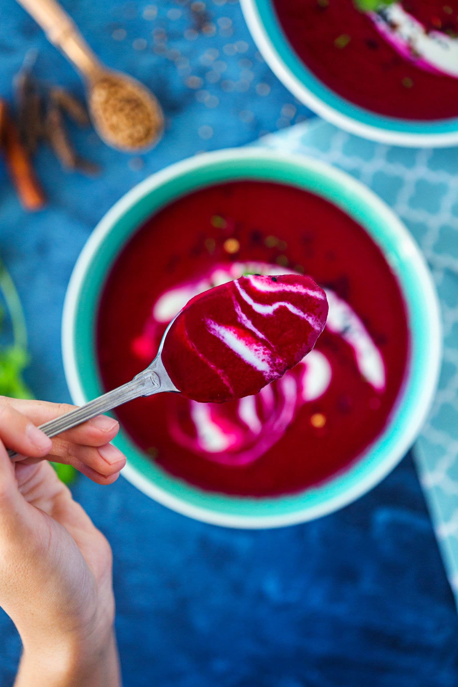 Spoonful of creamy beetroot and apple soup lifted from the bowl.
