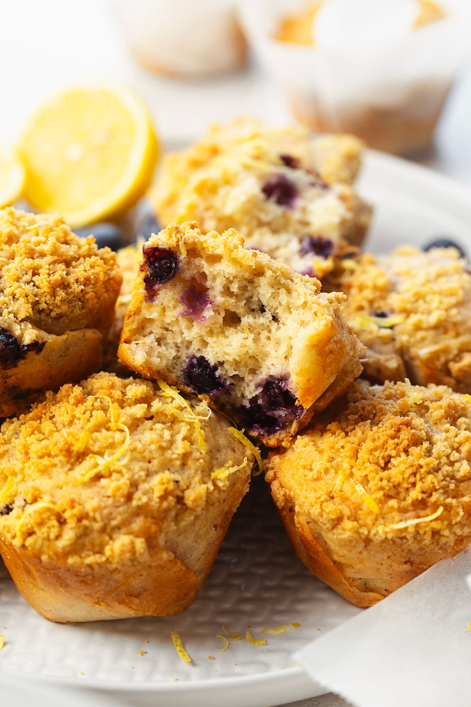 Lemon blueberry muffin torn in half, revealing a soft crumb with juicy blueberries inside.