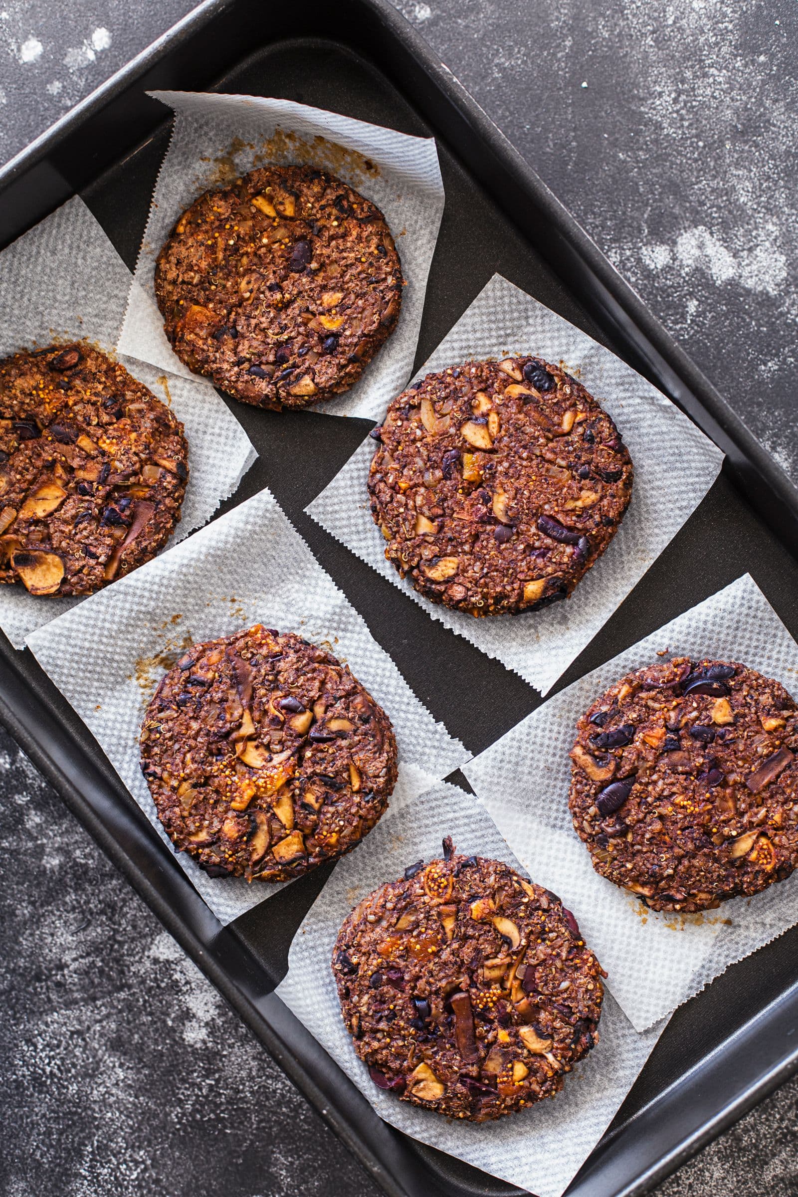 Cooked black bean patties on a baking tray, golden and crispy.