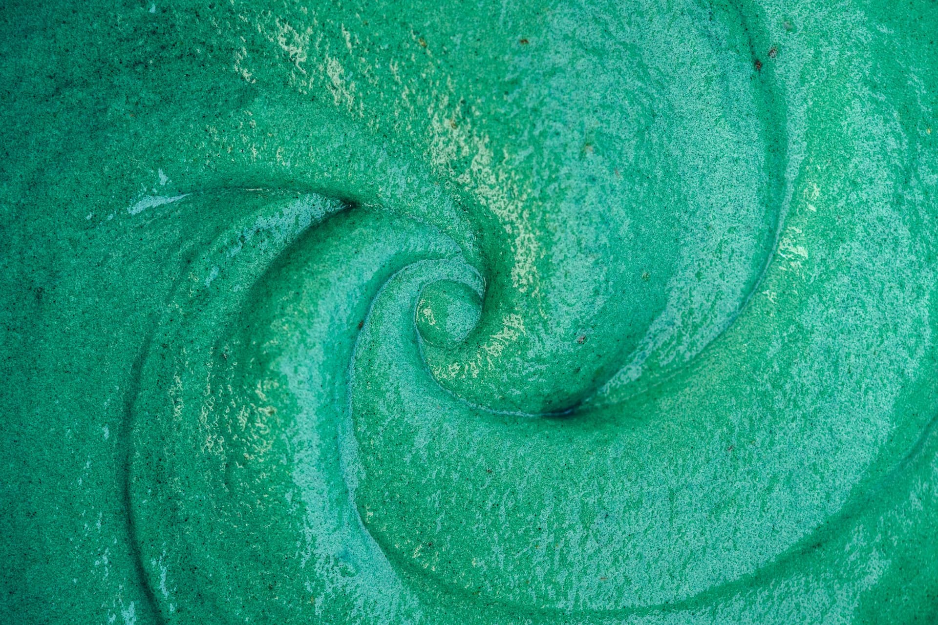 Vivid green spirulina nicecream freshly blended, shown in a swirling pattern.