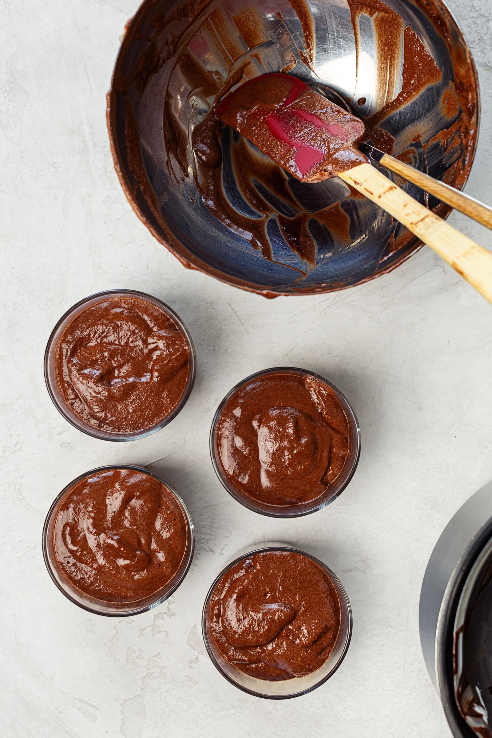 Individual glass cups filled with vegan chocolate mousse before decorating.