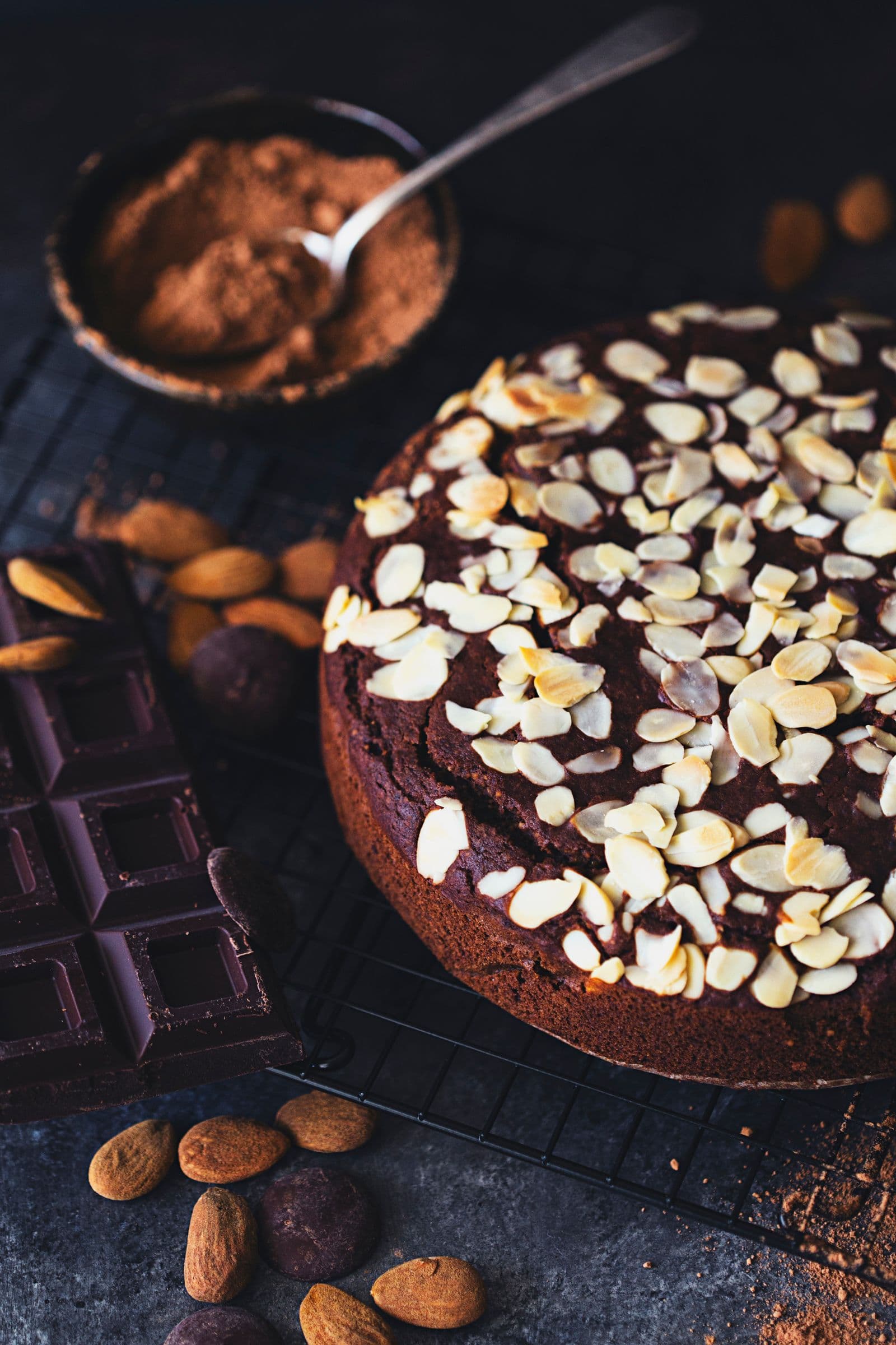 Bolo acompanhado de cacau, chocolate e amêndoas inteiras.